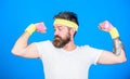 Motivated athlete guy. Sportsman training with dumbbells blue background. Improve your muscles. Man bearded athlete