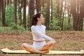 Motivated athletic positive woman in white leggins and top, practicing yoga, sitting in lotus pose and turning back, flexibility Royalty Free Stock Photo