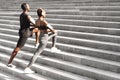 Motivated Black Couple Warming Up Muscles Before Jogging Outdoors On Urban Stairs Royalty Free Stock Photo