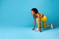 Black Lady Runner Standing In Crouch Start Position, Blue Background