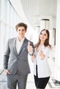 Motivated businessman and woman giving a thumbs up gesture of approval and success as they pose side by side giving the camera big Royalty Free Stock Photo