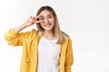 Motivated charismatic cute asian blond girl aim victory show peace disco sign eye smiling broadly, easygoing female Royalty Free Stock Photo