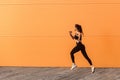 Motivated confident fit woman athlete in tight sportswear, black pants and top, starting to run, jogging outdoor