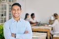 Motivated, confident and happy business man standing arms crossed in the boardroom for a meeting with his colleagues in