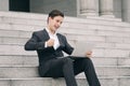 Motivated expression young business man sitting on stairs  working with his laptop Royalty Free Stock Photo