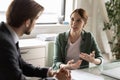 Motivated female employee talk discuss ideas with colleague Royalty Free Stock Photo