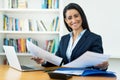 Motivated hispanic mature businesswoman working with documents at desk