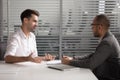 Motivated male applicant talk with recruiter at interview