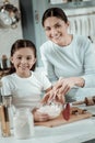 Motivated mother and daughter cooking dinner together