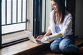 Motivated woman with disability using prosthetic arm working notebook computer, typing text, disabled cyborg girl normal