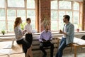 Happy millennial four mixed race teammates discussing project ideas. Royalty Free Stock Photo