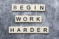 The motivating slogan Begin Work Harder formed with tile letters