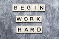 The motivating slogan Begin Work Harder formed with tile letters