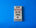 Motivation and changes symbol. Concept words Stay motivated in the times of changes on wooden blocks. Beautiful blue background. Royalty Free Stock Photo