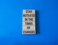 Motivation and changes symbol. Concept words Stay motivated in the times of changes on wooden blocks. Beautiful blue background. Royalty Free Stock Photo