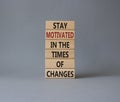 Motivation and changes symbol. Concept words Stay motivated in the times of changes on wooden blocks. Beautiful grey background. Royalty Free Stock Photo