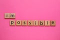 Motivation concept. Changing word from Impossible into Possible by removing wooden square with letters I and M