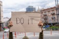 Motivation from a guy with sign. Do it. Banner message on street. Royalty Free Stock Photo