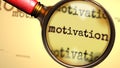 Motivation and a magnifying glass on English word Motivation to symbolize studying, examining or searching for an explanation and