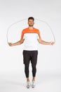 Motivation, sport and health concept. Handsome charming young sportsman in activewear, jump with jumping rope, look