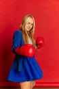 Motivation for success. Funny young business woman or happy student wearing blue suit boxing over bright red background