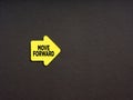 Motivational concept for improvement in business or career. Yellow arrow shaped sticker with the word move forward on black Royalty Free Stock Photo