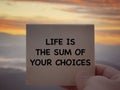 Motivational and inspirational wording. Life Is The Sum Of Your Choices written on a notepad. With blurred styled background.