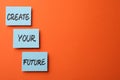 Motivational phrase Create Your Future made of sticky notes with words on orange background. Space for text Royalty Free Stock Photo
