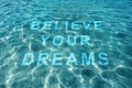 Motivational quote Believe Your Dreams, view on text through ocean water