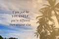 Motivational quote on blurred palm trees against blue sky background.