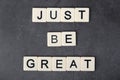 A motivational quote Just be great formed with tile letters