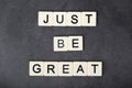 A motivational quote Just be great formed with tile letters