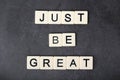 A motivational quote Just be great formed with tile letters