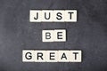 A motivational quote Just be great formed with tile letters