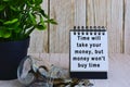 Motivational quote on paper stand and blurred glass jars with multicurrency coins