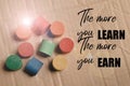 Motivational quote written with THE MORE YOU LEARN, THE MORE YOU EARN Royalty Free Stock Photo