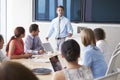 Motivational Speaker Talking To Businesspeople In Boardroom