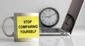 Motivational sticky note message on coffee mug reading Stop Comparing Yourself on Royalty Free Stock Photo