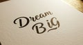 Motivational typography design: "dream big" in elegant black script on textured paper Royalty Free Stock Photo