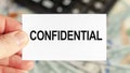 A man holds a piece of paper with the text: CONFIDENTIAL. Business and finance concept Royalty Free Stock Photo