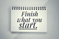 Motivational words - Finish what you start. Text message on a spiral notebook. Inspirational quote concept on paper book.