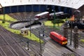A miniature locomotive depot with railroad tracks, locomotives and buildings..