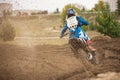 Moto cross - MX girl biker at race in Russia - a sharp turn and the spray of dirt, rear view Royalty Free Stock Photo