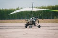 Moto hang glider takes off from grass runway. Rear view