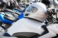 Moto helmet lies on the gas tank of a motorcycle and motorbikes on blurred background. Royalty Free Stock Photo