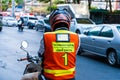 Moto taxi driver in bangkok. View from the back, a man in a vest with a pocket of a taxi driver s license