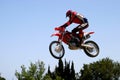 Moto X Motorbike jumping through the air on a hot sunny day with big blue sky Royalty Free Stock Photo