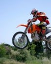 Moto X Motorbike jumping through the air on a hot sunny day with blue sky Royalty Free Stock Photo