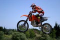 Moto X Motorbike jumping through the air on a hot sunny day with blue sky Royalty Free Stock Photo