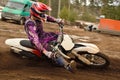Motocross athlete raised leg forward executes turning Royalty Free Stock Photo